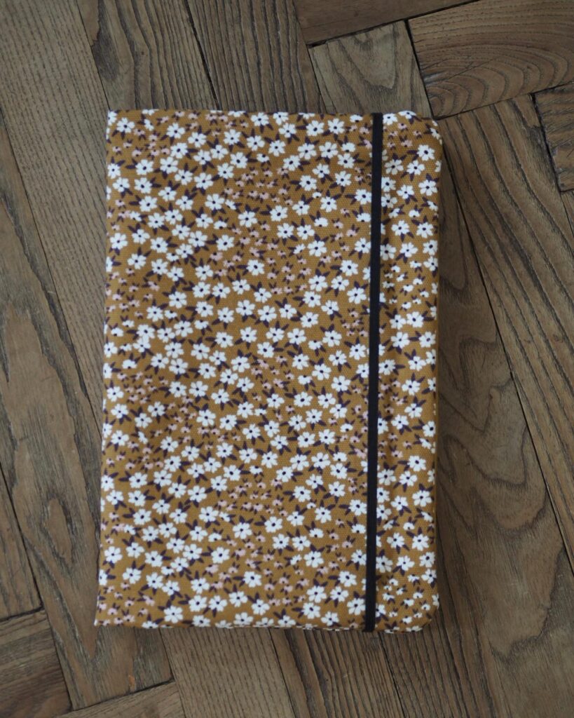 Booksleeve mit Blumenmuster auf einem Holzboden