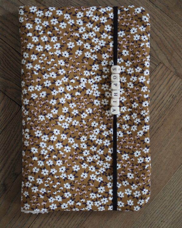 Booksleeve mit Blumenmuster in Honiggelb und Namensperlen am Gummiband