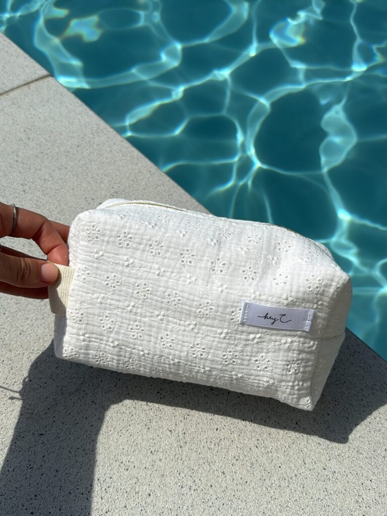 Weiße Kosmetiktasche mit Struktur am Poolrand