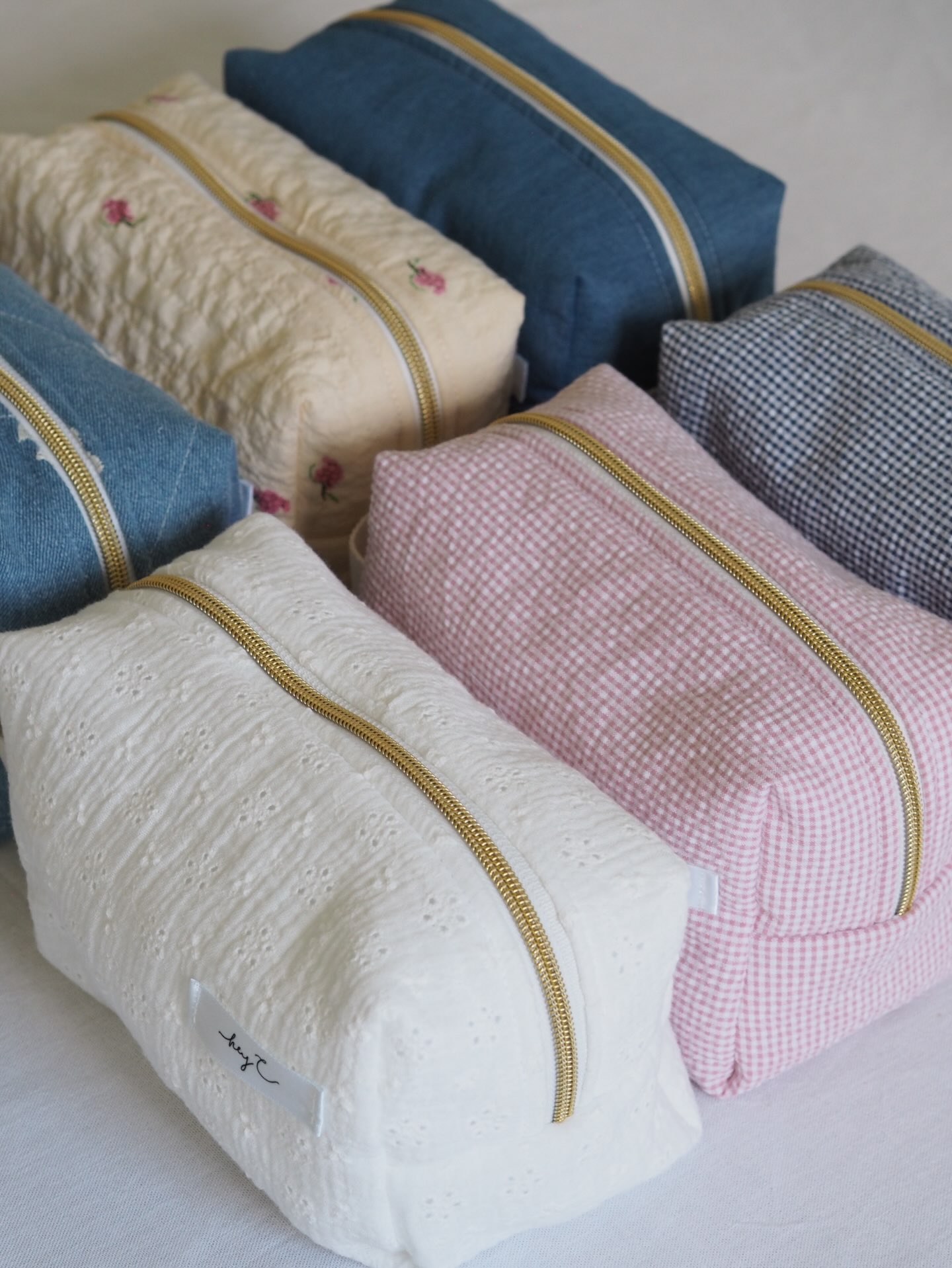 Gesteppte Kosmetiktaschen in Weiß, Rosa und Jeansblau mit goldenen Reißverschlüssen
