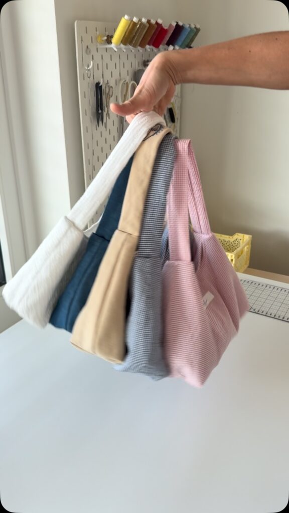 Mehrere Mini Summer Bags in verschiedenen Stoffen an einer Hand