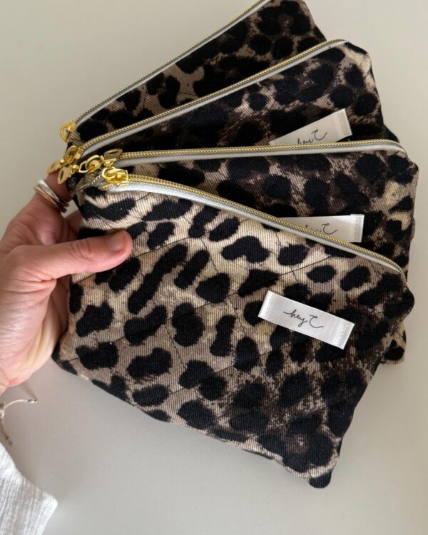 Mehrere Pouches mit Leoprint in der Hand gehalten
